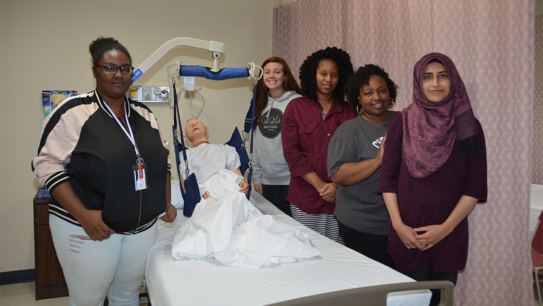Students standing around a hospital bed