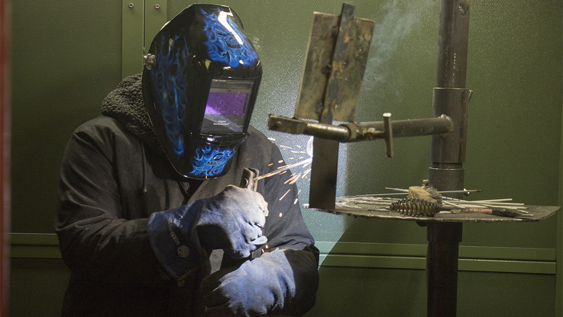 Person welding a piece of steel