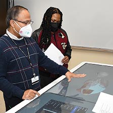 Dr. Subrata Biswas uses an Anatomage table to show lung anatomy to students in a biology class.