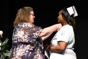 faculty member pins nursing grad