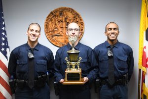 three police officers with trophy